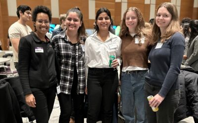 a group of women gather for a photo, their smiles exuding warmth, encapsulating a moment of joy and solidarity among them.