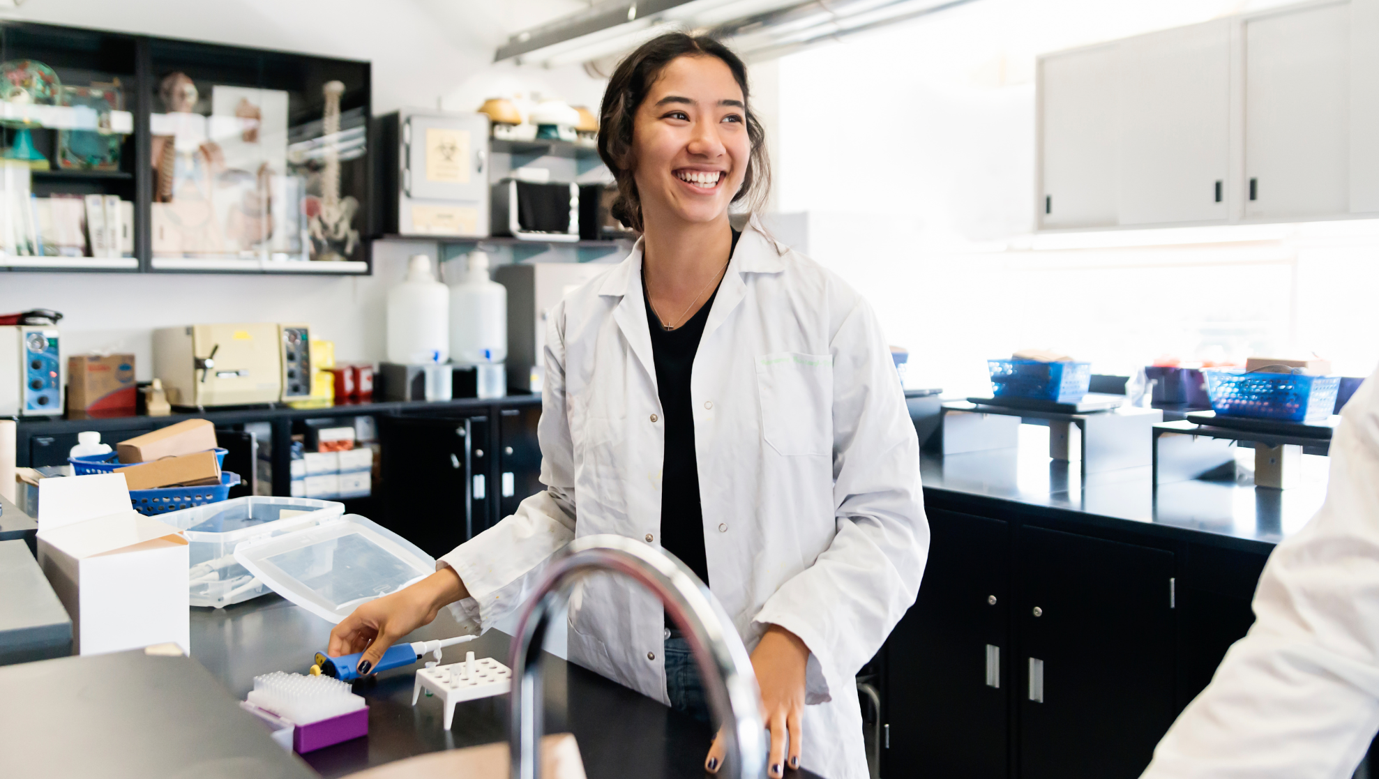 A Calgary based  summer student smiling at her desk.