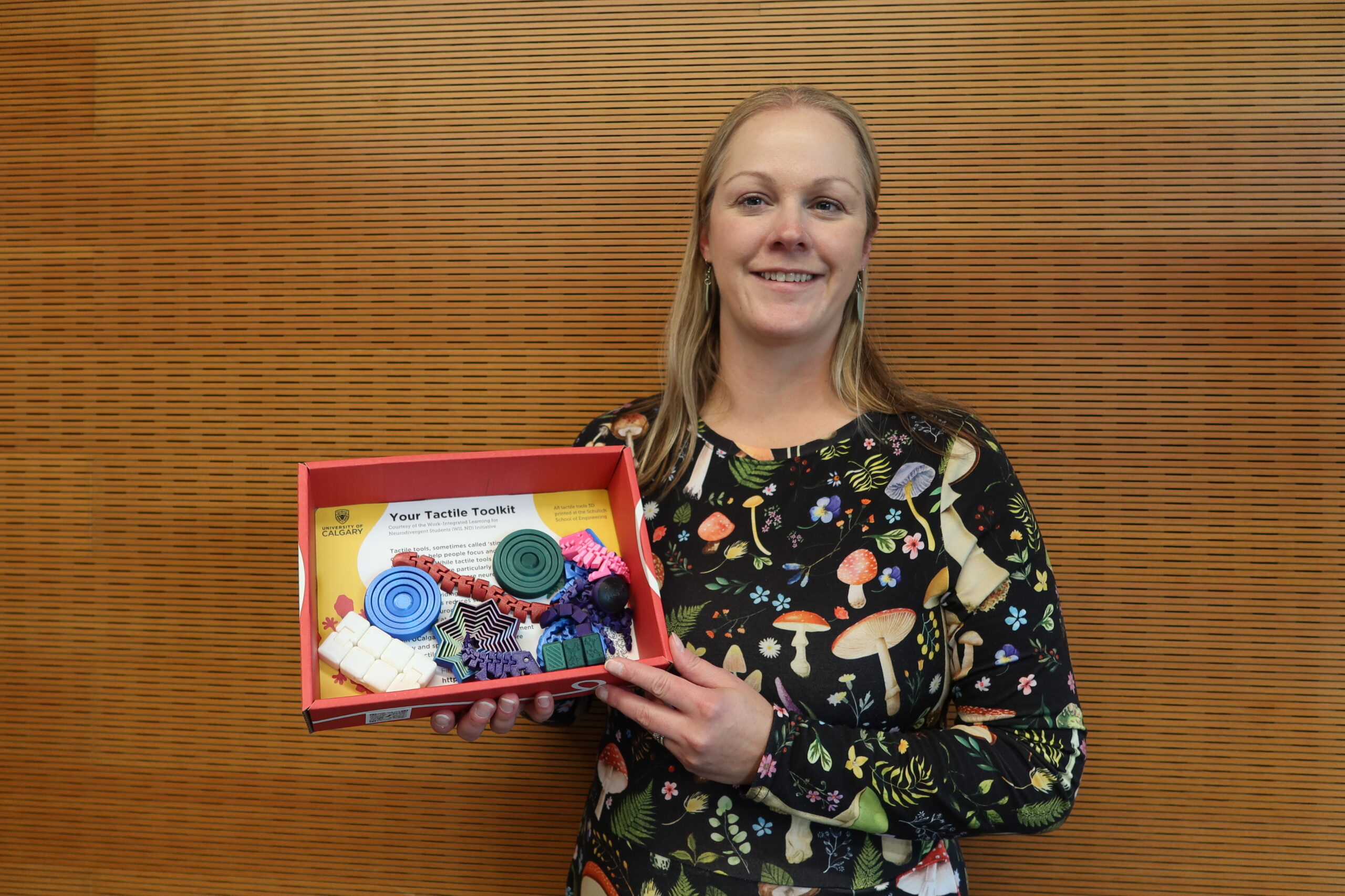 A woman holding a box of sensory tolls for neurodivergent students.